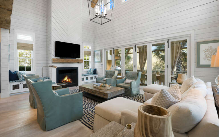 Unwind in your spacious living room with cozy fireplace, flat-screen TV, and elegant coastal furnishings perfect for relaxing evenings.