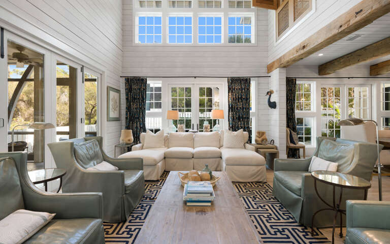 Unwind in this stunning living room where soaring ceilings, exposed beams, and soft natural light create your perfect retreat.