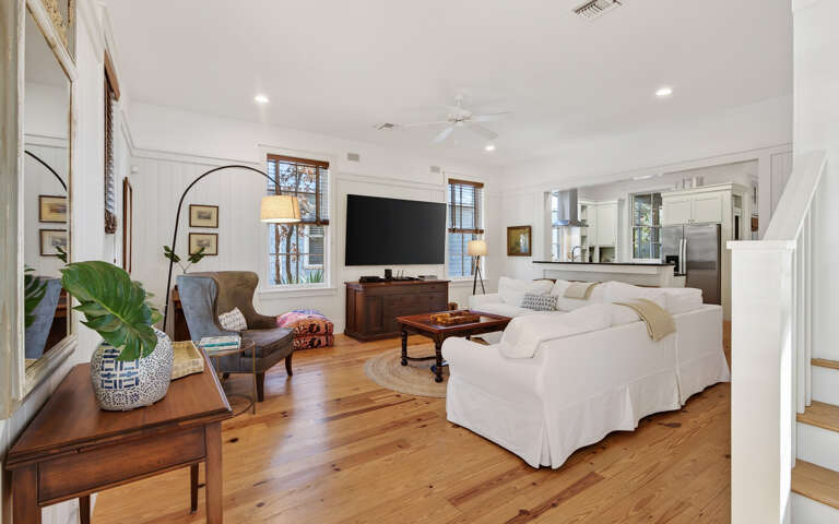 Sink into plush white sofas surrounded by warm wood floors and thoughtful coastal touches that create your perfect relaxation retreat.