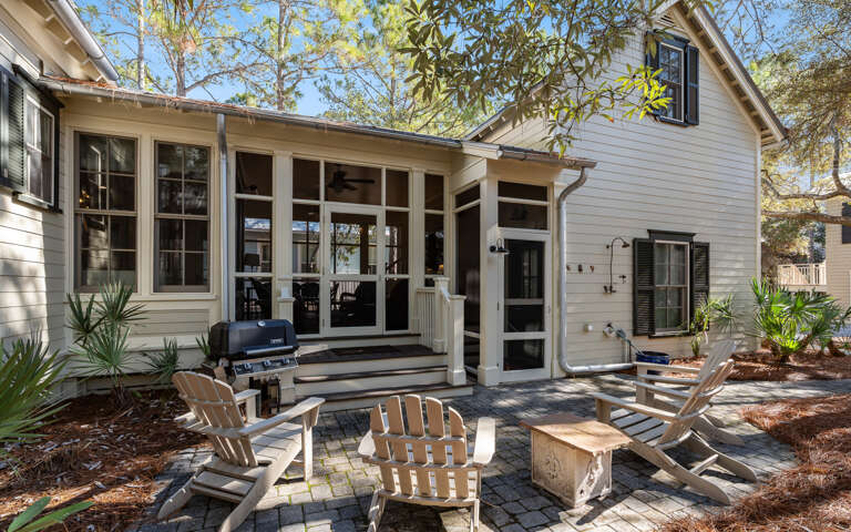 Charming coastal cottage with spacious screened porch and brick patio creates your perfect outdoor retreat.