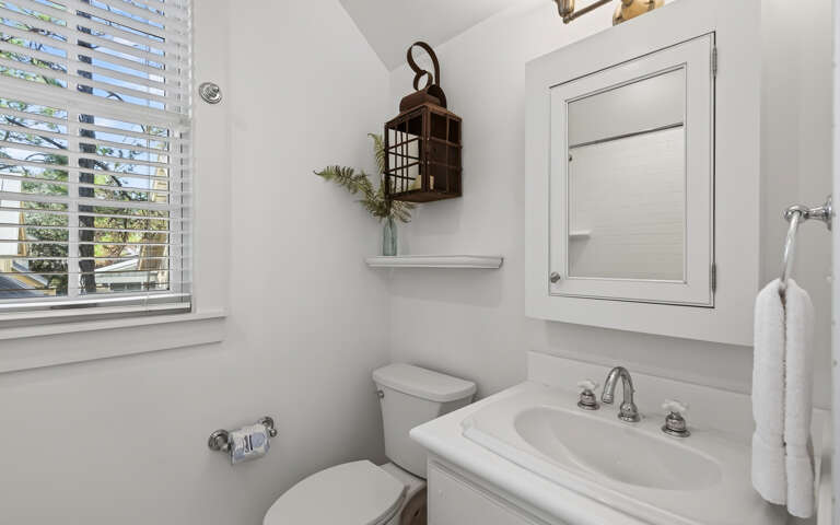 Freshen up in your bright, clean bathroom with thoughtful touches and natural light streaming through plantation shutters.