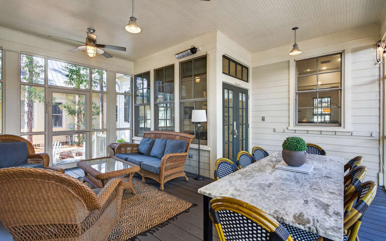 Your spacious screened porch offers the perfect blend of indoor comfort and outdoor living, with cozy wicker seating and elegant dining.