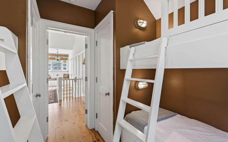 Cozy bunk room with built-in beds and warm lighting creates your perfect family retreat.