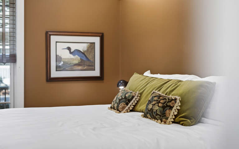 Sink into crisp white linens with decorative pillows that add warmth to your peaceful retreat.