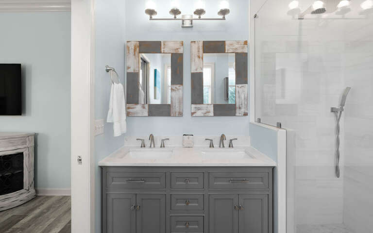 Step into your beautifully appointed bathroom featuring dual vanities, stylish mirrors, and a spacious shower for your refreshing getaway.