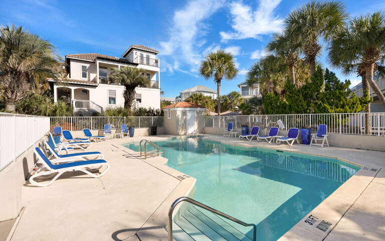 The community pool oasis awaits with sparkling blue waters surrounded by comfortable lounge chairs, perfect for soaking up the Florida sunshine.