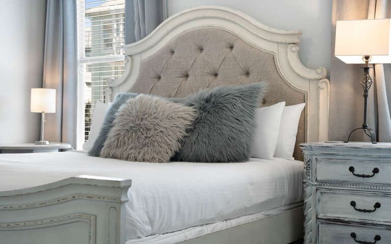 Sink into the plush linens and fluffy pillows of your elegantly appointed bedroom, where soft lighting creates the perfect ambiance for rest.