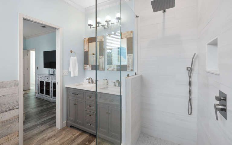 Your private bathroom features a spacious glass shower, double vanity with rustic mirrors, and modern fixtures for a refreshing start to your day.