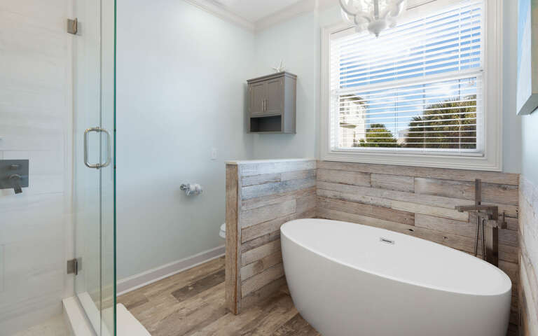 Soak in your elegant freestanding tub surrounded by rustic wood accents and natural light streaming through the window.