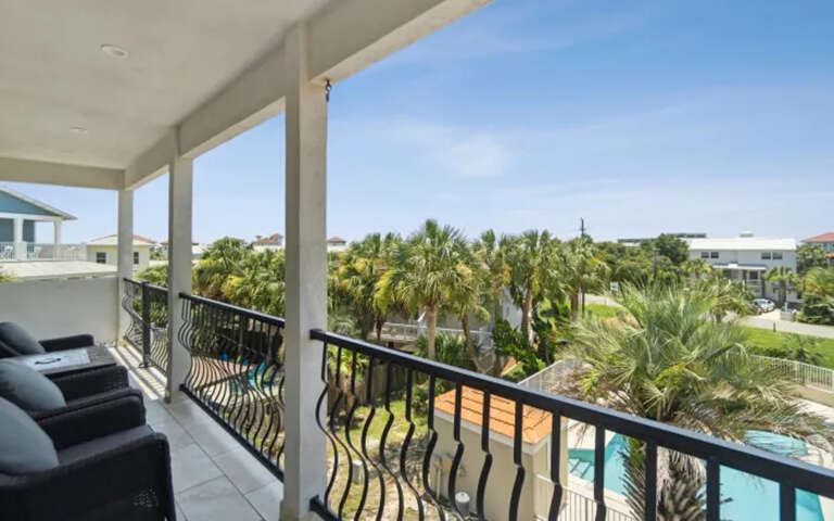 Relax on your private balcony with comfortable seating while enjoying tropical views of swaying palms and sparkling pool below.