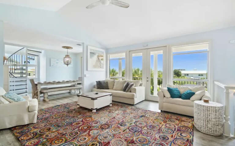 Sink into plush sofas in your bright living room, where colorful rugs and coastal views create the perfect retreat.