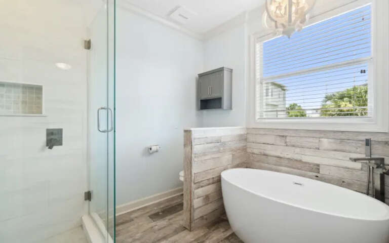 Soak your stresses away in this luxurious freestanding tub, perfectly positioned beside natural light streaming through elegant windows.