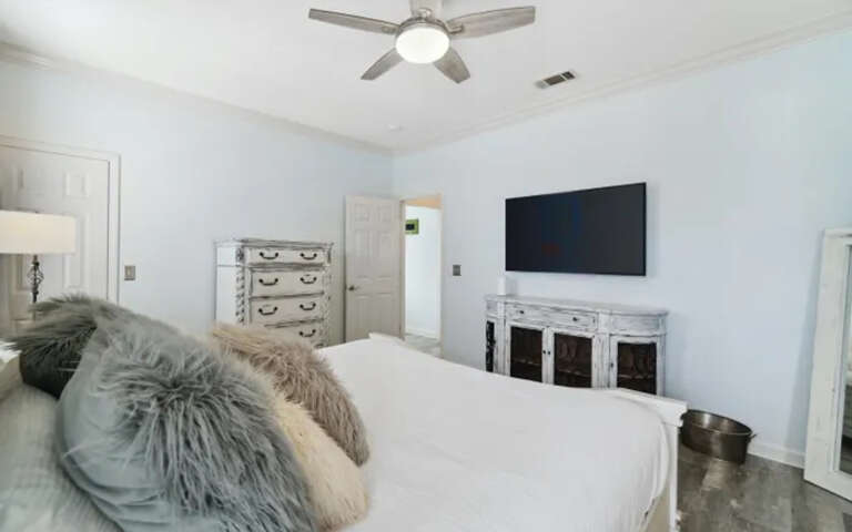 Your spacious master bedroom features a cozy king bed, flat-screen TV, and ample storage with charming rustic furnishings.