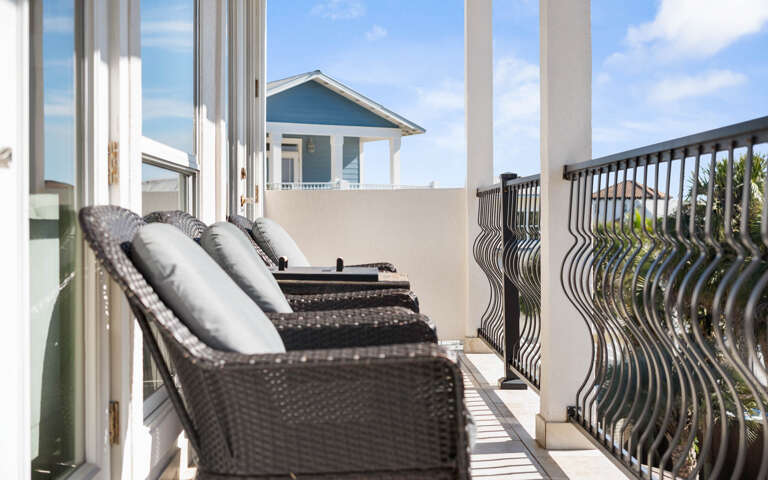 Step onto your private balcony where comfortable wicker loungers invite you to unwind while enjoying the beautiful coastal surroundings and fresh ocean breeze.