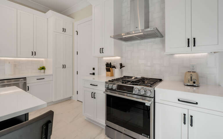 Your modern kitchen awaits with sleek white cabinetry, premium stainless appliances, and warm under-cabinet lighting for perfect meal prep.