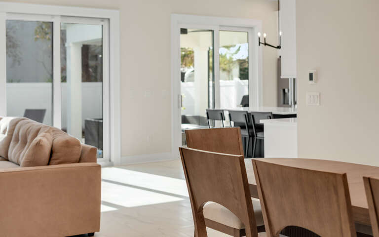 Relax in your bright, open living space where warm wood dining meets cozy seating, all flowing seamlessly to your private outdoor area.