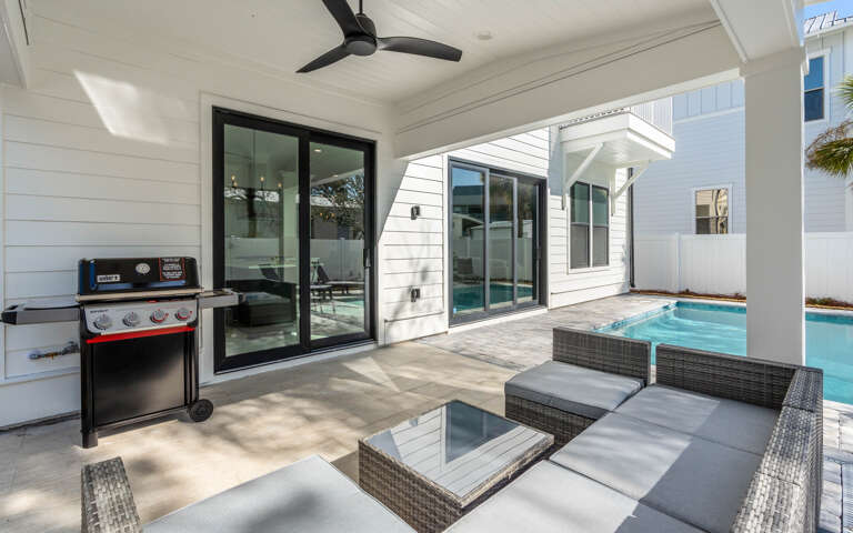 Relax poolside under your covered patio with BBQ, modern seating, and refreshing pool steps away for the perfect vacation retreat.