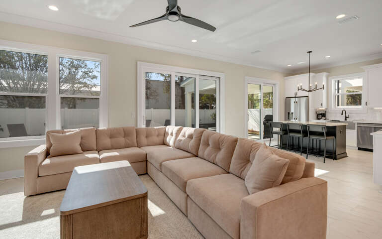 Relax in your spacious living room where plush sectional seating meets modern elegance, bathed in natural light from expansive windows.