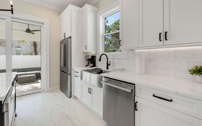 Your sleek modern kitchen features crisp white cabinetry, premium stainless steel appliances, and pristine countertopsâperfect for preparing memorable meals during your stay.