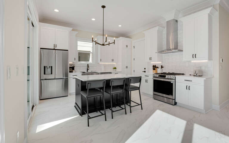 Step into your gourmet kitchen where crisp white cabinets and sleek countertops create the perfect space for culinary adventures and morning coffee moments.