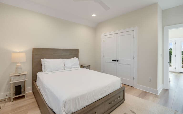 Unwind in your serene bedroom featuring crisp white linens, warm wood tones, and thoughtful storage solutions for the perfect night's rest.