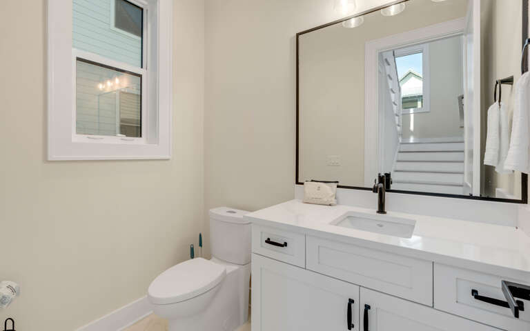 Your private bathroom features clean white vanity, stylish fixtures, and natural light from the window.