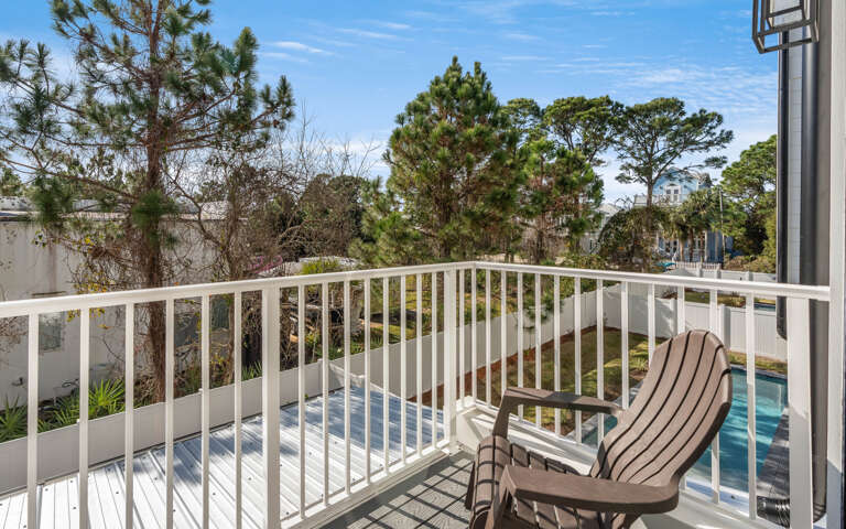 Your private balcony offers a peaceful retreat with comfortable seating and views of lush greenery and the sparkling pool below.