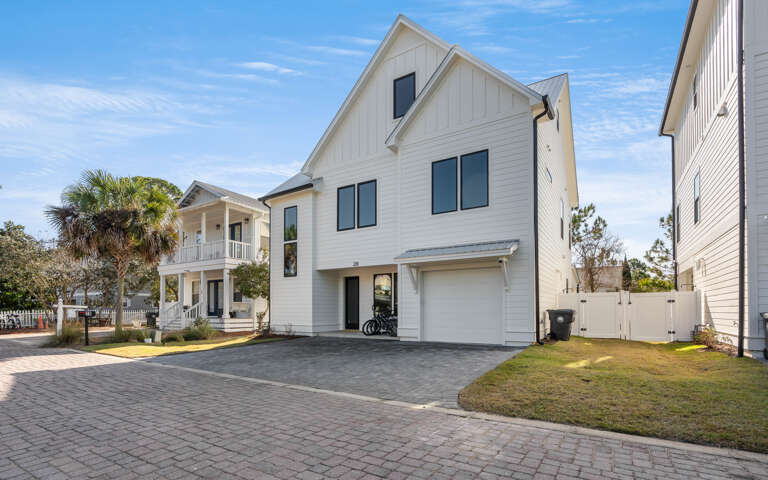 Modern coastal home featuring a spacious driveway and attractive neighborhood setting perfect for your beach getaway.