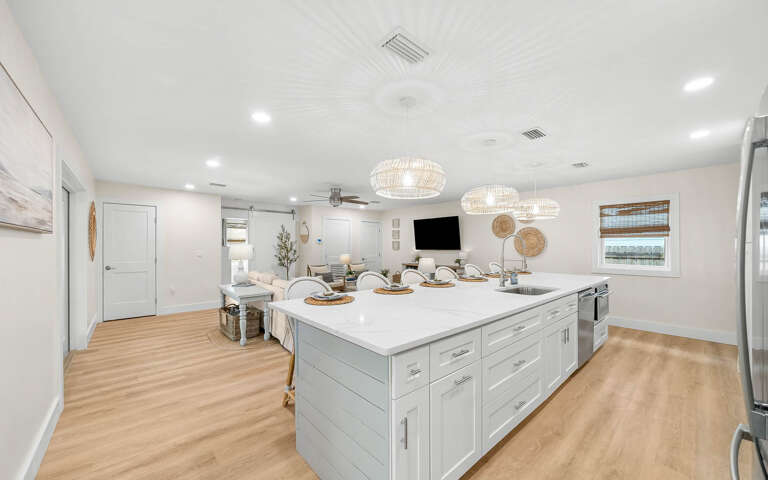 Your culinary dreams come alive in this bright open kitchen with gleaming counters, pendant lights, and seamless flow to the living area.