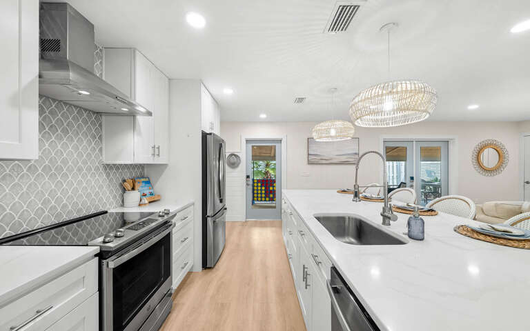 Your gourmet kitchen awaits with sleek white cabinetry, sparkling quartz countertops, and premium stainless appliances ready for culinary adventures.