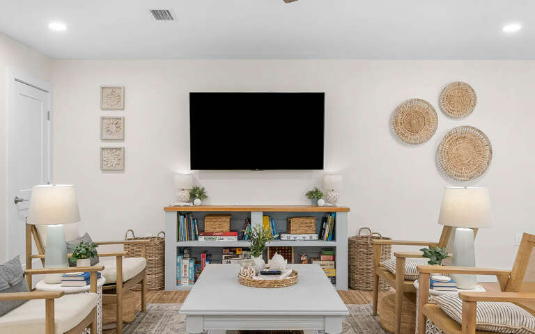 Relax in your bright living space with comfy seating, entertainment center, and coastal-inspired decor that creates the perfect atmosphere for unwinding.