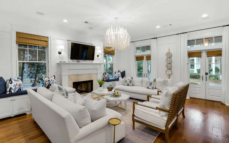 Sink into plush seating by your cozy fireplace, where elegant lighting and natural views create your perfect evening retreat.