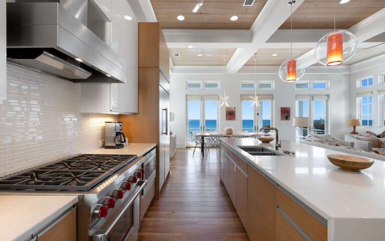 Your gourmet kitchen awaits with professional-grade appliances and stunning ocean views through floor-to-ceiling windows.
