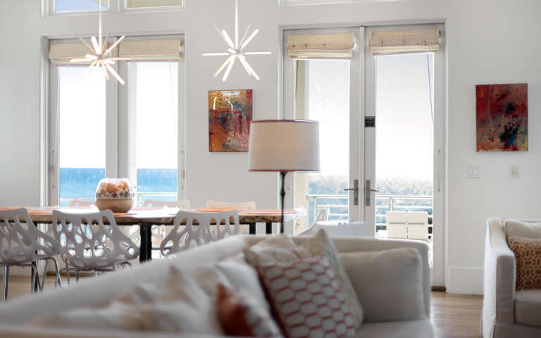 Relax in your bright, airy living space where modern furnishings meet stunning ocean views through floor-to-ceiling windows.