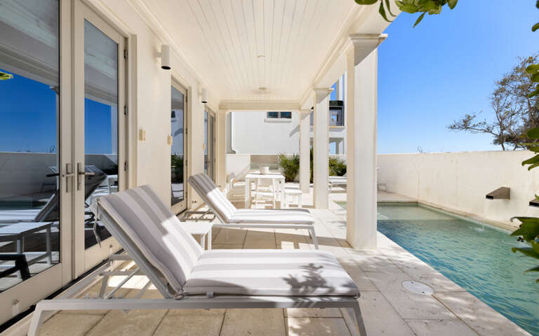 Unwind on your private poolside terrace, where elegant lounge chairs await beneath a covered pavilion for the perfect blend of sunshine and shade.