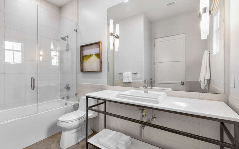 Unwind in your sleek bathroom with modern finishes, a glass-enclosed tub, and elegant lighting that creates the perfect spa-like retreat.