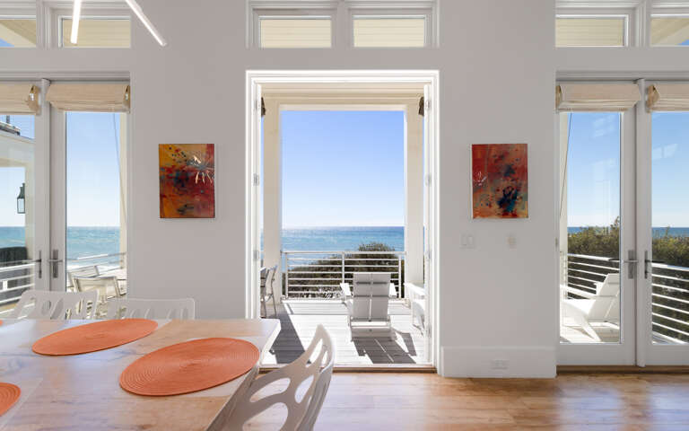 Your bright dining space opens to stunning gulf views through floor-to-ceiling doors, creating perfect indoor-outdoor flow.