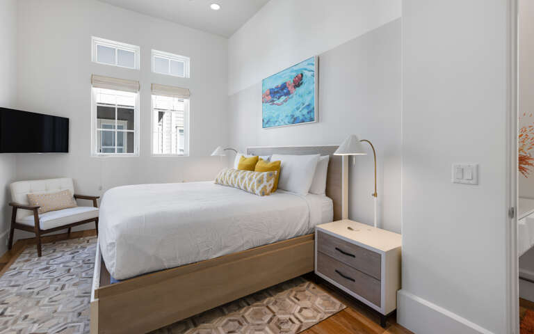 Sink into crisp linens and enjoy morning light streaming through your windows in this stylish bedroom retreat.
