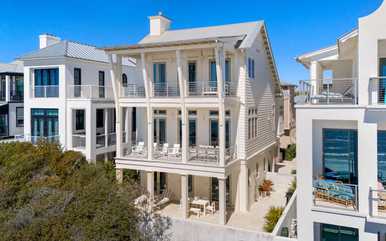 Stunning coastal architecture features multiple levels of covered porches and modern balconies in this beachside neighborhood.
