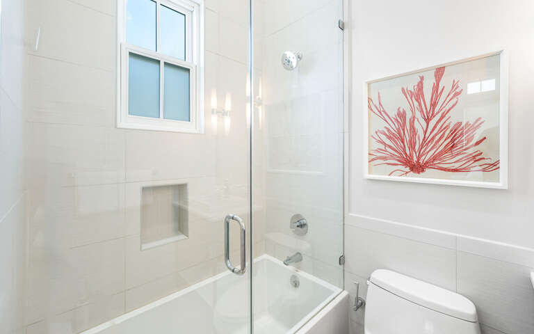 Unwind in your elegant bathroom featuring a luxurious glass-enclosed tub, perfect for soaking away the day's adventures.