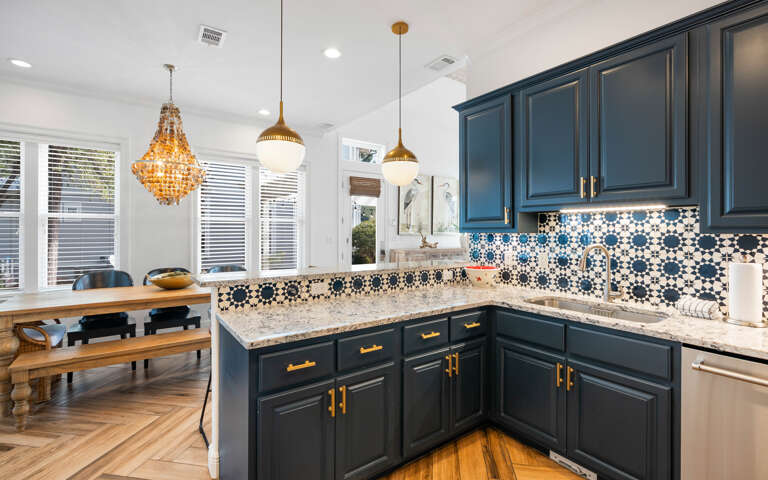 Your gourmet kitchen features navy cabinets, gold hardware, and stunning mosaic tilesâperfect for creating memorable meals together.