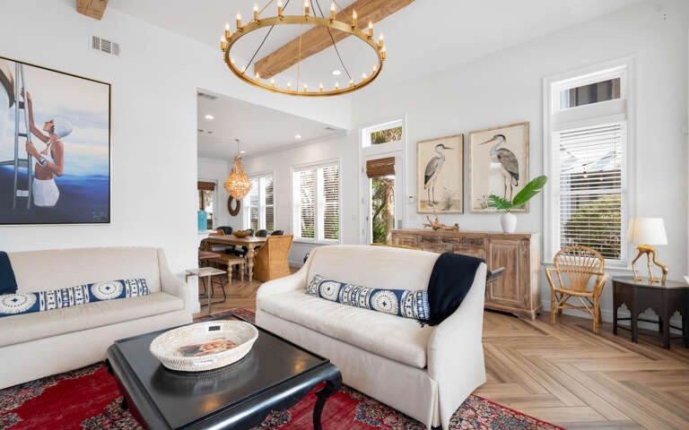 Sink into plush seating surrounded by coastal-inspired artwork and warm wood accents, where natural light streams through plantation shutters.