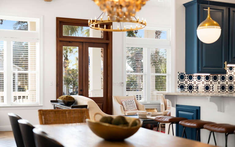 Your stylish kitchen flows seamlessly into the living area, where warm lighting and coastal views create the perfect space for cooking and relaxing together.