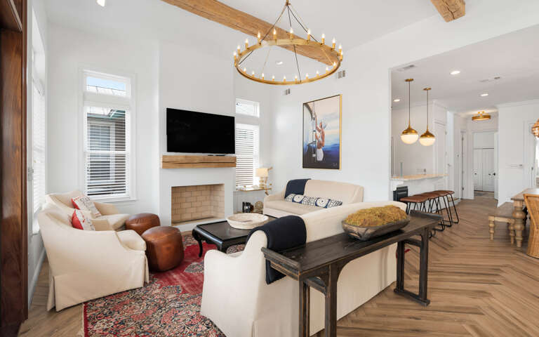 Unwind in your elegant living space with vaulted ceilings, rustic beams, and cozy fireplace creating the perfect atmosphere for relaxation.