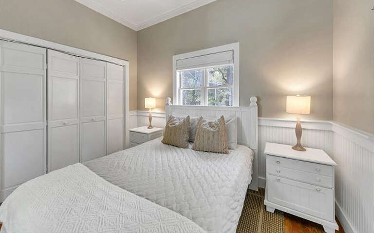 Sink into crisp white linens in your peaceful bedroom sanctuary, where soft lighting and elegant furnishings create the perfect retreat.