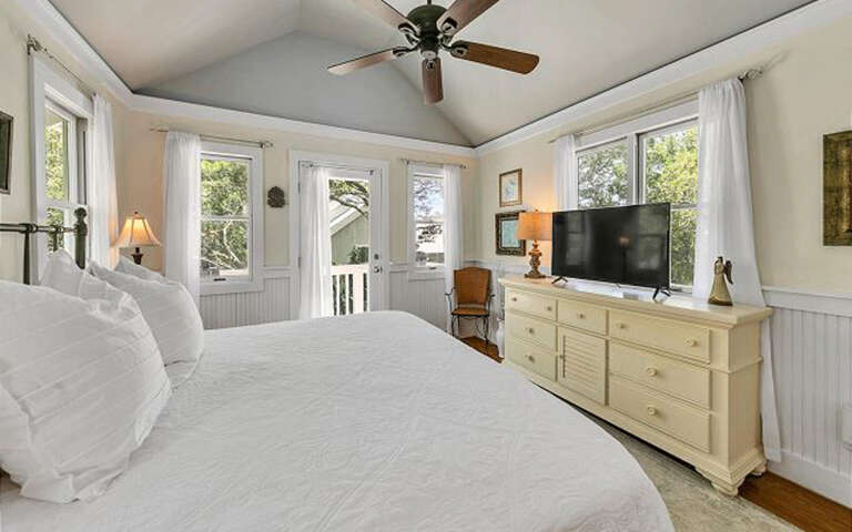 Unwind in your bright, airy bedroom where ceiling fans and large windows create perfect comfort for restful nights.
