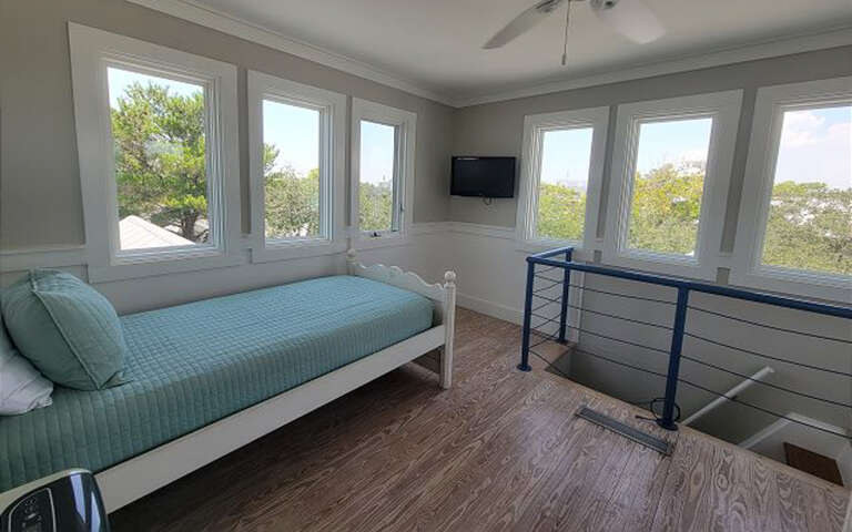 Wake up to stunning treetop views from your bright bedroom, where coastal breezes flow through multiple windows and modern comfort meets natural beauty.