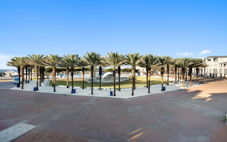 A promenade featuring palm trees and public spaces creates a scenic coastal atmosphere near the property.
