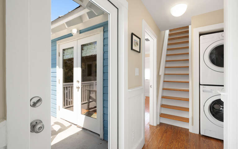 Step into your bright entryway featuring convenient laundry facilities and elegant wooden stairs leading to your upstairs retreat.