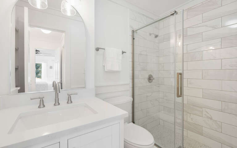 Step into your pristine marble bathroom with elegant subway tile and glass shower—a spa-like retreat for your morning routine.